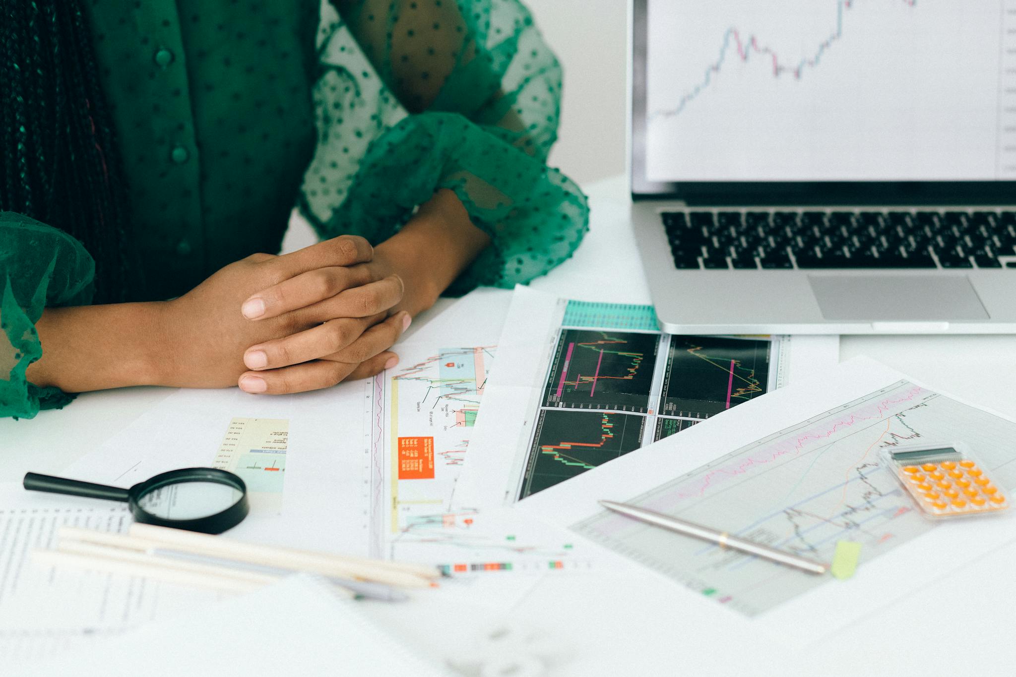 Our Mission A person analyzes financial charts and graphs at a desk, indicating business trading activity.
